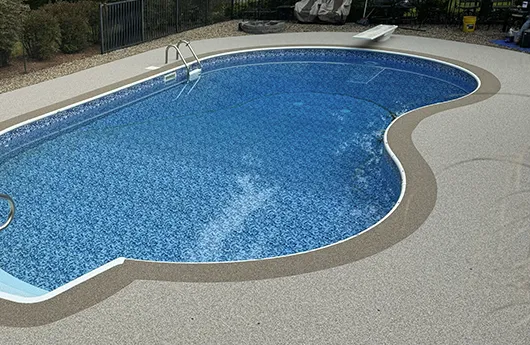 UV-resistant exterior concrete coating system applied to a swimming pool area for enhanced safety and weather protection.