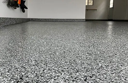 Close-up of a durable multi-layered grey flake epoxy garage floor system installed by RL Epoxy Flooring in Manchester, NH.